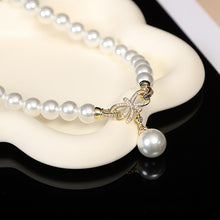 Cargar imagen en el visor de la galería, Conjunto de collar de perlas Chic Elegance con colgante de lazo en tono dorado y detalles de cristal 
