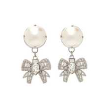 Cargar imagen en el visor de la galería, Pendientes en tono platino con lindos y elegantes lazos adornados con perlas de resina de gran tamaño y cristales blancos.
